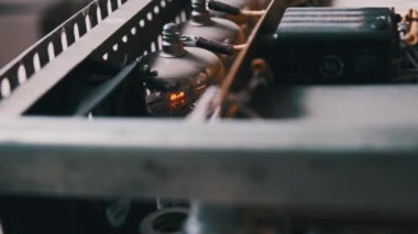 Ev yapımı ses yükselticinin içinde parlayan radyo tüpleri. Eski devreler, radyo parçaları, kablolar. Amplifikatör panosundaki elektronik vakum tüpleri. Eski moda valf yükselticisi. Eski moda lamba. 4K