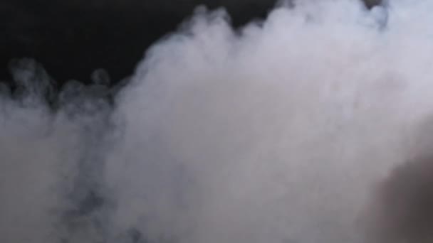 スローモーションで黒い背景の煙や蒸発雲 ホワイトスチームが上がる フローティングフォグ 本物の大気効果 煙の質の抽象粒子 スペースをコピーする 4Kについて — ストック動画