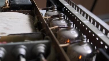 Ev yapımı yüksek çözünürlüklü ses yükselticisinin içinde parlayan vakum tüpleri. Eski devreler, radyo parçaları, kablolar. Amplifikatör panosundaki elektronik radyo tüpleri. Eski moda valf yükselticisi. 80 'ler, retro lambalar