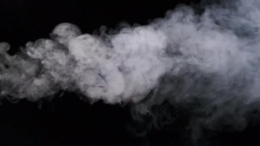 Ağır çekimde siyah arka planda sigara içmek. Patlama buharı. Gerçek bir beyaz duman bulutu ya da buhar yükselir. Yüzen sis. Atmosferik etki, soyut duman dokusu parçacıkları, FX. Uzayı kopyala 4K.