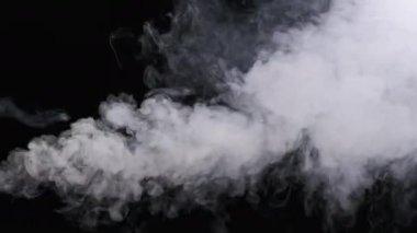 Ağır çekimde siyah arka planda duman veya buhar akımı. Patlama buharı. Beyaz duman bulutları yükseliyor. Yüzen sis. Gerçek atmosferik etki, soyut duman dokusu parçacıkları. Boşluğu kopyala