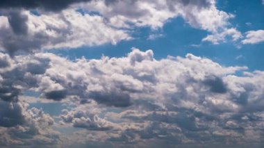 Timelapse of cumulus clouds moving in the blue sky. Cloud space background with dark, light and grey clouds changing shape, time lapse. Change of weather. Nature, sky clouds, copy space