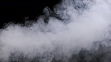 Ağır çekimde siyah arka planda duman veya buhar akımı. Patlama buharı. Beyaz duman bulutları yükseliyor. Yüzen sis. Gerçek atmosferik etki, soyut duman dokusu parçacıkları. Boşluğu kopyala