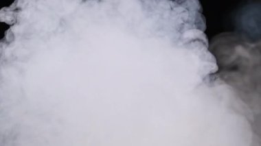 Siyah arka planda duman ya da buhar bulutu. Beyaz buhar yükseliyor. Yüzen sis. Gerçek atmosferik etki, soyut duman dokusu parçacıkları. Kopyalama. 4K