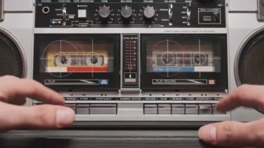 Klasik bir teypten müzik. Eski bir ses kasedinin analog sesi. Masadaki iki kaset çalar üzerindeki erkek el ile oynatma düğmesine bas ve müzik dinle. 80 'lerden kalma bir teyp kaydı.