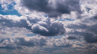 Timelapse of cumulus clouds moving in the blue sky. Cloud space background with dark, light and grey clouds changing shape, time lapse. Change of weather. Nature, sky clouds, copy space