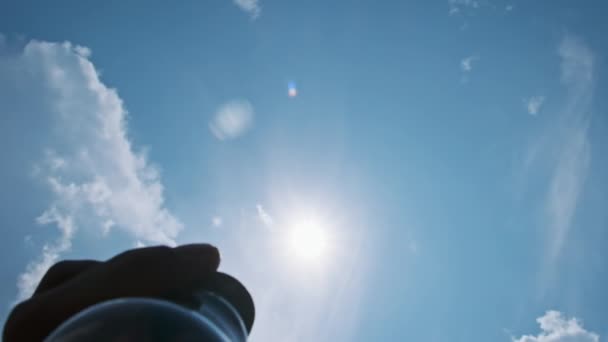 男性の手は明るい太陽によって白熱した電球を空に投げます スローモーション 透明な電気ランプを握る人間の手のPovシルエット エコロジー 代替ソーラーエネルギー — ストック動画