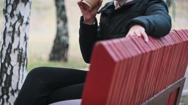Młoda Kobieta Pije Kawę Papierowego Kubka Ławce Jesiennym Parku Kobiety — Wideo stockowe