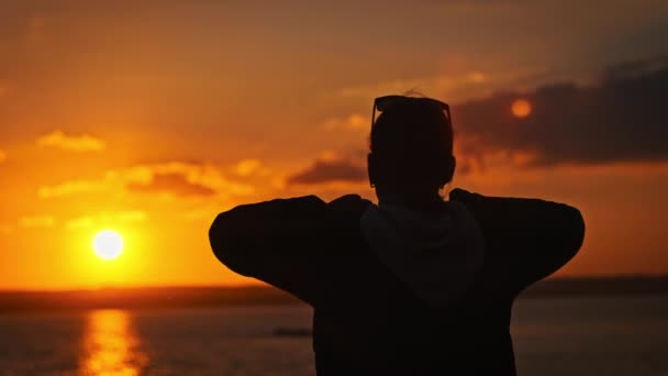Silhouette Einer Jungen Frau Hebt Die Hände Gegen Den Sonnenuntergang — Stockvideo