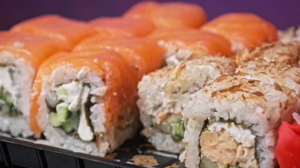 筷子把一个寿司放进寿司盒里 在塑料盒里打滚 日本的一套各种美味的寿司卷在一个运送容器里 亚洲概念食品 健康食品 外卖食品 — 图库视频影像