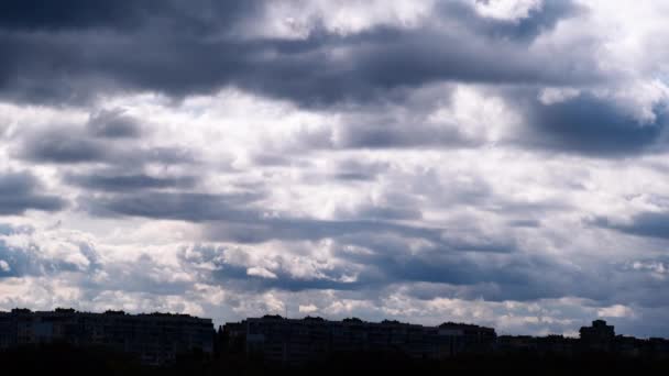 风暴云经过的时间在高层建筑物屋顶的轮廓上移动 城市上空乌云密布 云彩景观房子的屋顶 云彩飘过 大范围拍摄 时间过去了4K — 图库视频影像