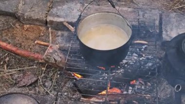 Doğadaki bir kamp ateşinde tencerede yemek pişirmek. Ormanda yürüyüş yapmak, ocakta piknik yapmak. Kamp gezisi için yiyecek hazırla. Ev yapımı tuğla ocakta yemek pişirmek. 4K