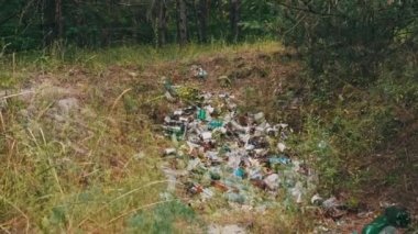 Yeşil ormana bir sürü çöp atıldı. Yasa dışı çöp bidonları ve yere plastik dökümü. Doğada sentetik atık yığını. Yasadışı çöplük. Orman ve doğa kirliliği