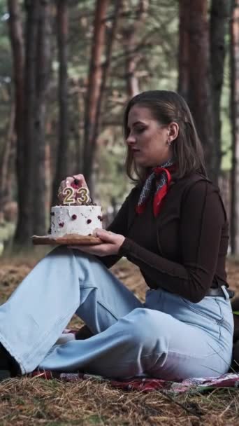 Vertikal Pretty Frau Bläst Kerzen Ihrem Geburtstag Kuchen Einem Kiefernwald — Stockvideo