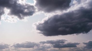 Kümülüs bulutlarının zamanı gökyüzünde hareket ediyor. Işık ve ağır sakin bulutların arka planı bulutlu uzayda şekil değiştirir. Doğal arka plan, hızlandırılmış zaman, kopyalama alanı. 4K