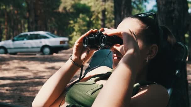 Μια Γυναίκα Κοιτάζει Μέσα Από Κιάλια Μια Σεζλόνγκ Ένα Δάσος — Αρχείο Βίντεο