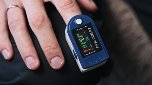 Человек Измеряет Пульс Насыщение Кислородом Помощью Пульсоксиметра Дома Современный Прибор — стоковое видео