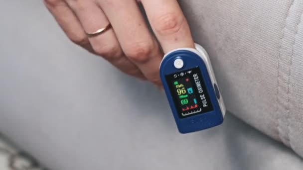 人間はパルスと酸素飽和を自宅で測定する 心拍数を測定する現代装置は心拍の健康を監視します 血液中の酸素レベルを監視する 医療技術について — ストック動画