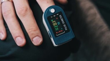 Nabız oksimetresi, erkek parmağındaki nabız ve oksijen doygunluğunu ölçer. Modern cihaz kalp atışlarını ve evdeki kalp atışlarını ölçüyor. Kan durumunu gözlemliyorum. Sağlık, tıp teknolojisi