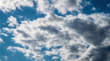 Kümülüs bulutlarının zamanı mavi gökyüzünde ilerliyor. Işık ve ağır sakin bulutların arka planı bulutlu uzayda şekil değiştirir. Doğal arka plan, hızlandırılmış zaman, kopyalama alanı. 4K.