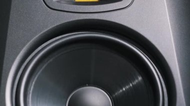 Stüdyo monitör hoparlörü bir kayıt stüdyosundaki bas müzik yüzünden titreşiyor, yakın plan. Modern hoparlör zarı ağır çekimde yüksek sesle şarkı dinlerken hareket eder. Düşük frekansta bas hoparlörü çalışıyor. HiFi