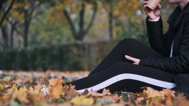 Молода Жінка Каву Сидячи Газоні Осінньому Парку Серед Опалого Жовтого — стокове відео