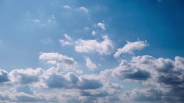 Kümülüs bulutlarının zamanı mavi gökyüzünde ilerliyor. Işık ve ağır sakin bulutların arka planı bulutlu uzayda şekil değiştirir. Doğal arka plan, hızlandırılmış zaman, kopyalama alanı. 4K.