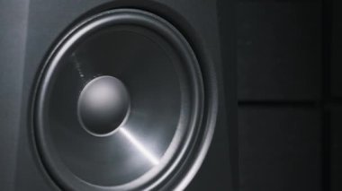 Stüdyo monitör hoparlörü bir kayıt stüdyosundaki bas müzik yüzünden titreşiyor, yakın plan. Modern hoparlör zarı ağır çekimde yüksek sesle şarkı dinlerken hareket eder. Düşük frekansta bas hoparlörü çalışıyor. HiFi