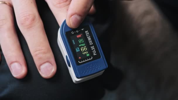 人間はパルスと酸素飽和を自宅で測定する 心拍数を測定する現代装置は心拍の健康を監視します 血液中の酸素レベルを監視する 医療技術について — ストック動画
