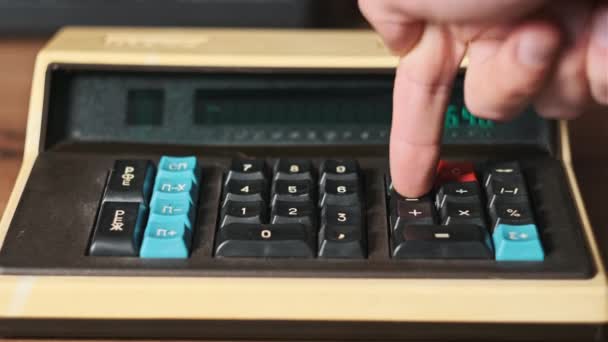 男子手压按钮在一个旧的复古计算机关闭的木制桌子上 用老式计算器计数 概念计算家庭财务 财务账单 — 图库视频影像