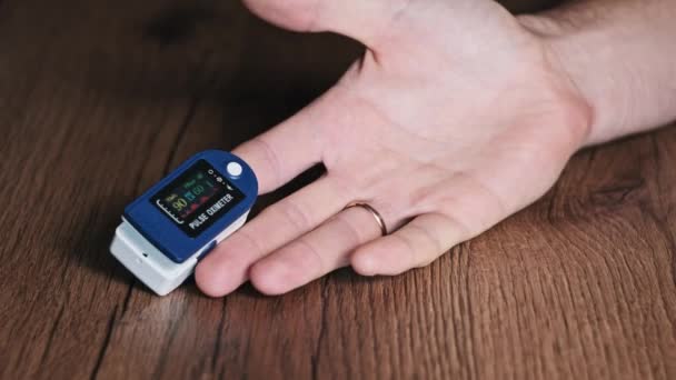 脉冲血氧计测量男性食指上的脉搏和氧饱和度 现代装置在家里测量心率 脉搏和心跳健康状况 监测血液状况 医疗技术 — 图库视频影像