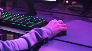 Genç oyuncu profesyonel bir oyun koltuğunda oturur ve E-spor kulübünde video oyunları oynar. Kulaklıklı bir çocuk bilgisayar kulübünde neon ışıkları olan bir video oyununa odaklanıyor. Oyun kulübünde genç, hobi olarak.