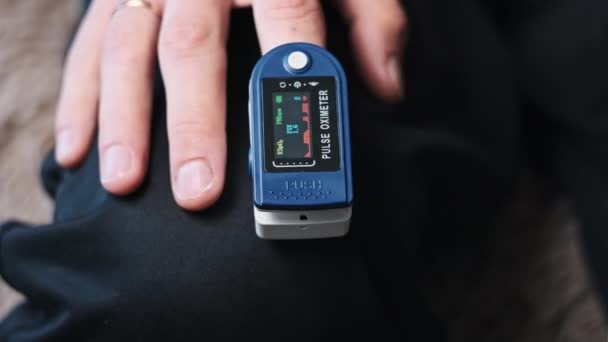 脉冲血氧计测量男性食指上的脉搏和氧饱和度 现代装置在家里测量心率 脉搏和心跳健康状况 监测血液状况 医疗技术 — 图库视频影像