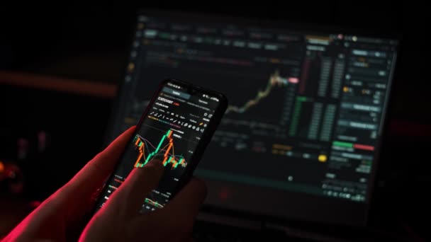 スマートフォンで株式市場のデータグラフを扱う暗号ビジネスマン 携帯電話アプリで仮想通貨をチェックする投資家 取引所グラフでオンラインBtc価格を分析するトレーダー ビットコインを購入 — ストック動画