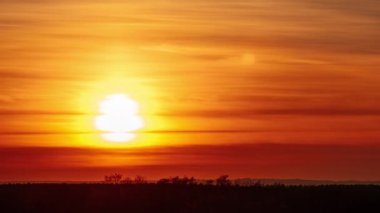 Turuncu gökyüzünde gün batımı yumuşak bulutlarla, Timelapse. 4 bin. Parlak güneş ufuktan batıyor. Dramatik renkli karanlık günbatımı destansı bulutları. Canlı bir renk. Zaman atlaması. Gün batımı, Bulutlar