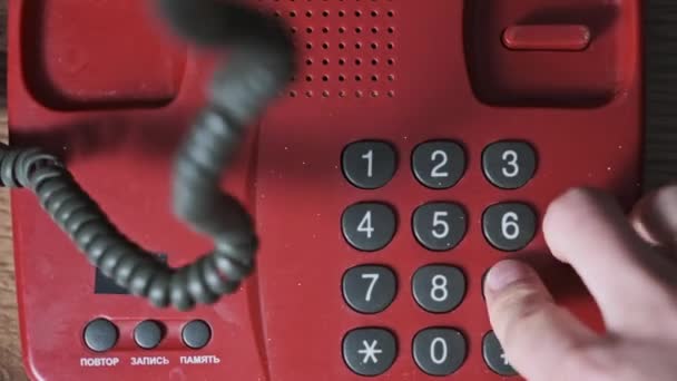 呼叫911 在旧式的红色电话上俯瞰全景 人们用手按下拨号键 在一个复古的家庭电话上拨打紧急电话号码 复古推盘电话上的数字按钮 后续行动 — 图库视频影像