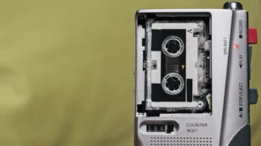 Antika Mikro Kaset Ses Kayıt Ses Kaydı Yeşil Arkaplanda. Kullanışlı bant retro çalar. Portatif eski kasetin boş etiketle yakın plan görüntüsü. Ses kaydı, arama kaydı, kopyalama alanı