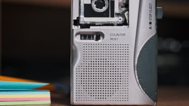 老式微型盒式磁带录音机立正录音 微型盒式磁带和录音机里的滚动磁带在木制桌子上的特写 电话录音 Rec语音 录音机 — 图库视频影像