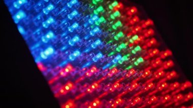 Birçok RGB LED 'i farklı renklerde parlar. Işık yayan diyotları olan panel ışıkları. Kırmızı, yeşil, mavi yarı iletken diyotların arka planı. Farklı efektlere sahip LED-noktalar. Yakın plan.
