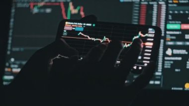 Kripto işadamı akıllı telefondan borsa veri grafiği üzerinde çalışıyor. Adam yatırımcı cep telefonu uygulamasında şifreli para kontrolü yapıyor. Döviz grafiğinde BTC fiyatını analiz eden tüccar. Bitcoin al