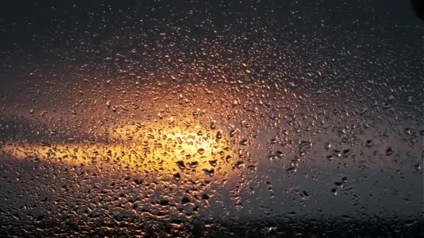 Dešťové Kapky Pomalu Stékají Sklem Okna Proti Zapadajícímu Slunci Oranžová — Stock video