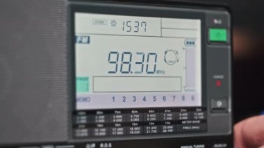 Modern radyonun dijital LCD ölçeğinde FM frekansı taranıyor. Çevirme paneli değişik radyo frekanslarıyla büyük rakamları gösteriyor. Taşınabilir radyo otomatik arama menzili. Akort alıcısı.