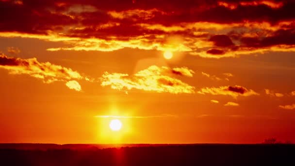 タイムラプス 劇的な雲でオレンジ色の空の地平線の上の驚くべき夕日 4Kについて 明るい太陽が地平線の上に沈んでいる カラフルなダークサンセットの壮大な雲 バリエーションカラー タイムラプス サンダウン — ストック動画