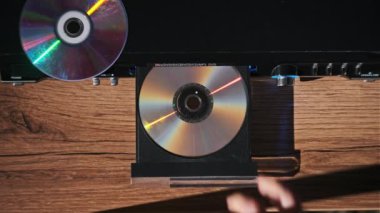 DVD CD CD oynatıcıdan çıkarılır. Erkek eli CD çalar tepsisinden CD indirir. Müzik, filmler ya da veriler bir lazer optik bilgi depolama aracına kaydedildi. Kompakt Disk Yükleniyor