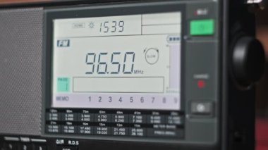 Modern radyonun dijital LCD ölçeğinde FM frekansı taranıyor. Çevirme paneli değişik radyo frekanslarıyla büyük rakamları gösteriyor. Taşınabilir radyo otomatik arama menzili. Akort alıcısı.