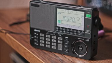 Masada dijital LCD ölçekli FM tarama frekansına sahip modern radyo. Taşınabilir radyo otomatik FM arama menzili. Çevirme paneli değişik radyo frekanslarıyla büyük rakamları gösteriyor. Yakın plan.