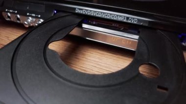 CD oynatıcıya CD sıkıştırıcı yükleniyor. Erkek eli CD 'yi CD çalar tepsisine yakın çekime koyar. Müzik, filmler ya da veriler bir lazer optik bilgi depolama aracına kaydedildi. Küçük Disk Yükleniyor