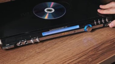 DVD CD CD oynatıcıdan çıkarılır. Erkek eli CD çalar tepsisinden CD indirir. Müzik, filmler ya da veriler bir lazer optik bilgi depolama aracına kaydedildi. Kompakt Disk Yükleniyor