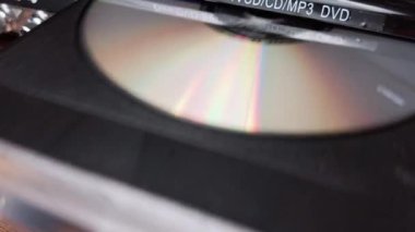 DVD CD CD oynatıcıdan çıkarılır. Erkek eli CD çalar tepsisinden CD indirir. Müzik, filmler ya da veriler bir lazer optik bilgi depolama aracına kaydedildi. Kompakt Disk Yükleniyor