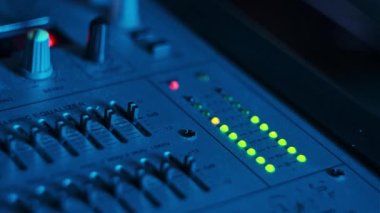 Neon ışıklı yakın plandaki karıştırma konsolundaki ses seviyesi sinyalinin LED göstergesi. Yeşil ve sarı LED çıkış seviyesi göstergesi. Ses düzeyi gösterge ışıklarını değiştirir. VU metre analog ses paneli